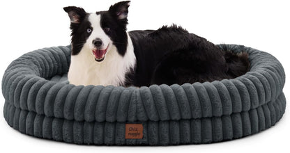 Dog lying on a gray plush dog bed with a visible brand logo.