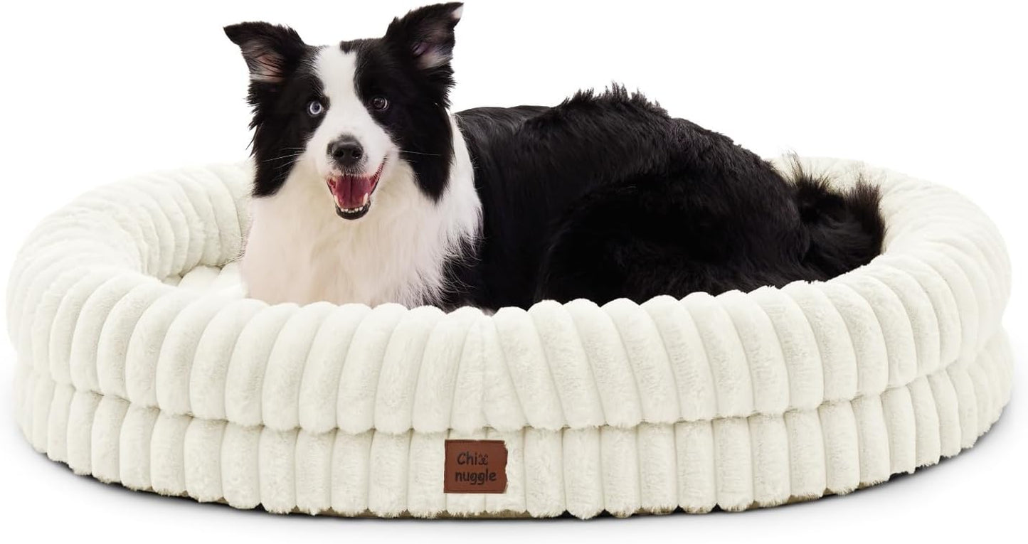 Dog lying on a white plush dog bed with a visible brand label.