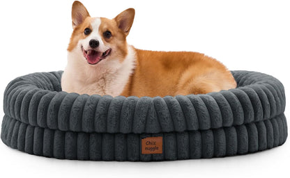 Dog lying on a gray plush dog bed with a visible brand logo.